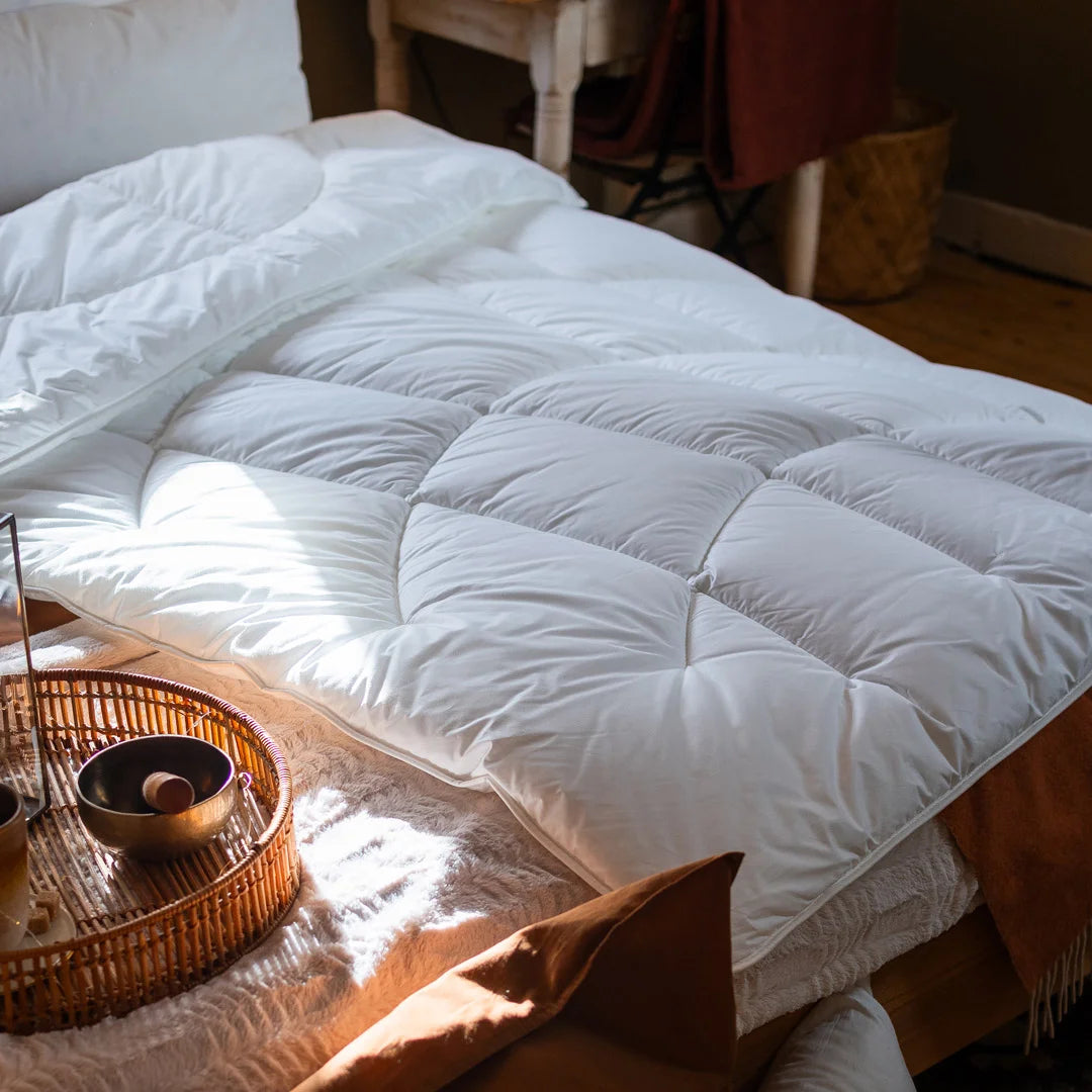 Weiße Paradies Runa Ganzjahresdecke mit Bodyform Steppung liegt sanft auf einem Bett ausgebreitet