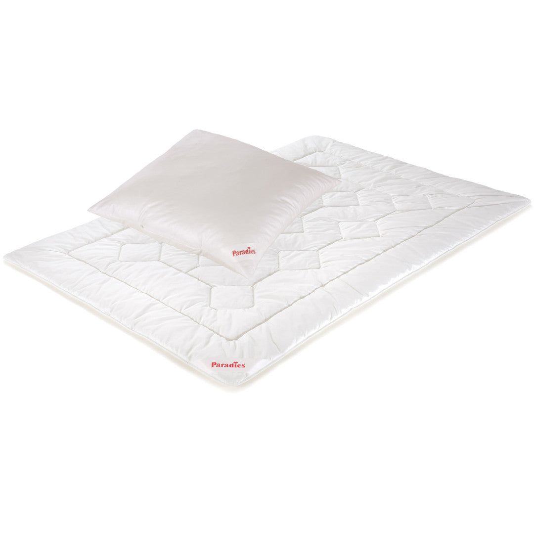 Weißes Steppbett und Kissen mit quadratischem Steppmuster und roten Markenaufdrucken